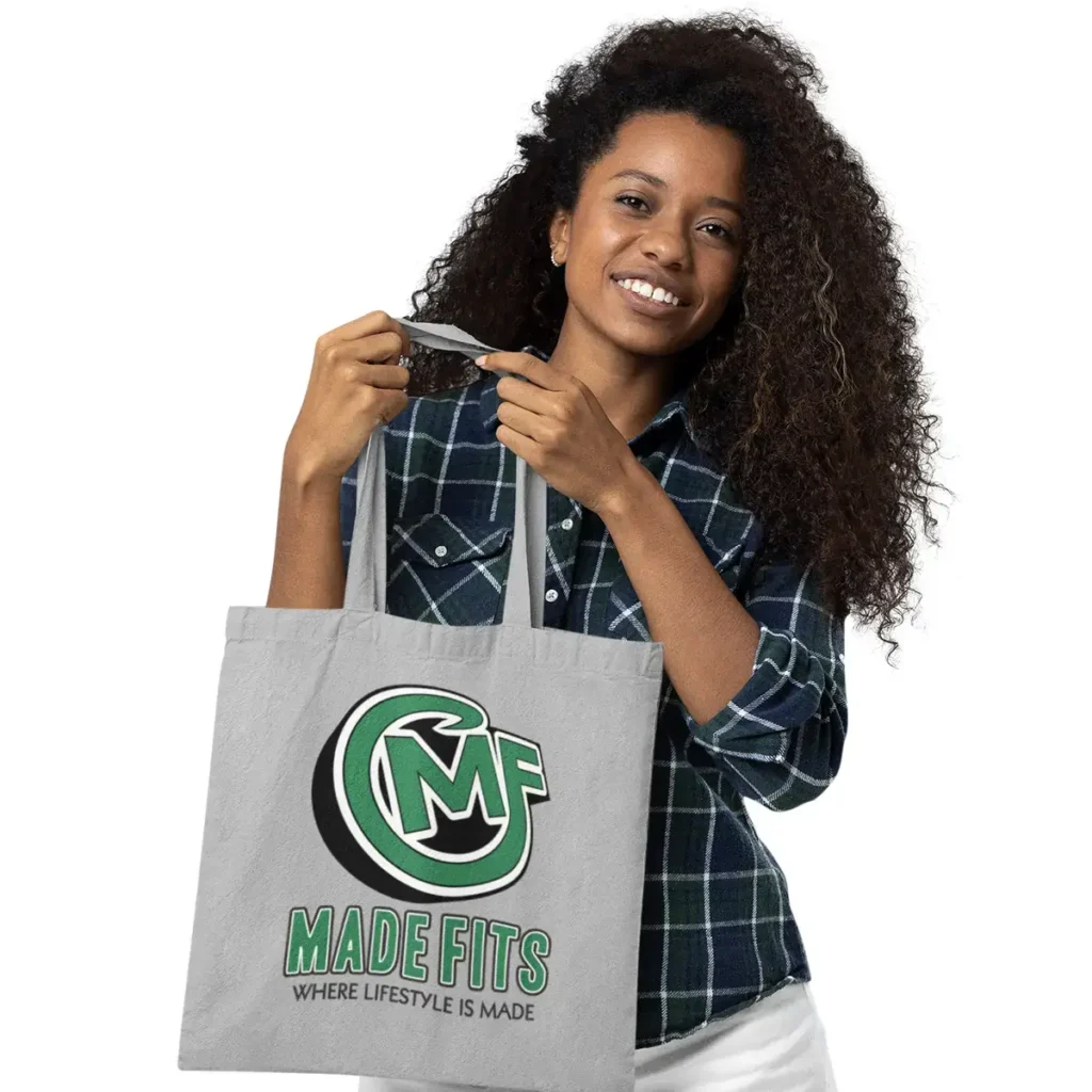 Woman holding a gray custom tote bag with MadeFits logo and slogan “Where Lifestyle is Made.”