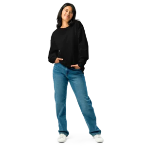 Woman wearing a black crewneck sweatshirt with a relaxed fit, paired with blue jeans in a casual stance.